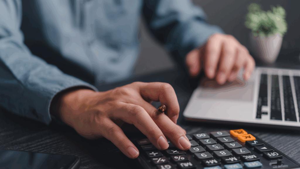 Obieg faktury w KSeF komputer biurko kalkulator i ręka pracownika podczas pracy z dokumentami