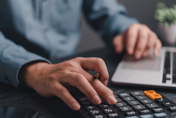 Obieg faktury w KSeF komputer biurko kalkulator i ręka pracownika podczas pracy z dokumentami