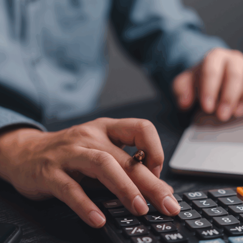 Obieg faktury w KSeF komputer biurko kalkulator i ręka pracownika podczas pracy z dokumentami