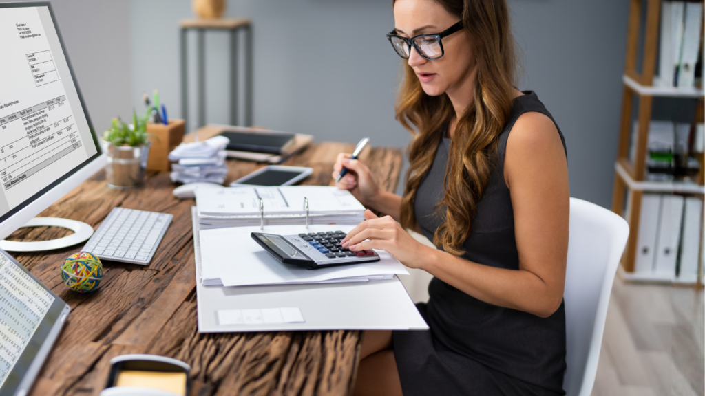 Pracownik biurowy przy komputerze - kobieta analizuje dokumenty i faktury w systemie KSeF