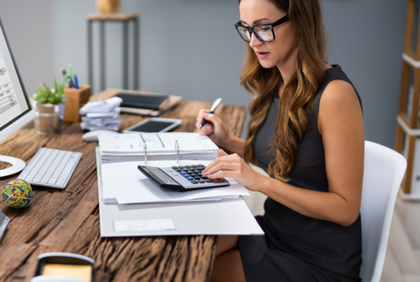 Pracownik biurowy przy komputerze - kobieta analizuje dokumenty i faktury w systemie KSeF