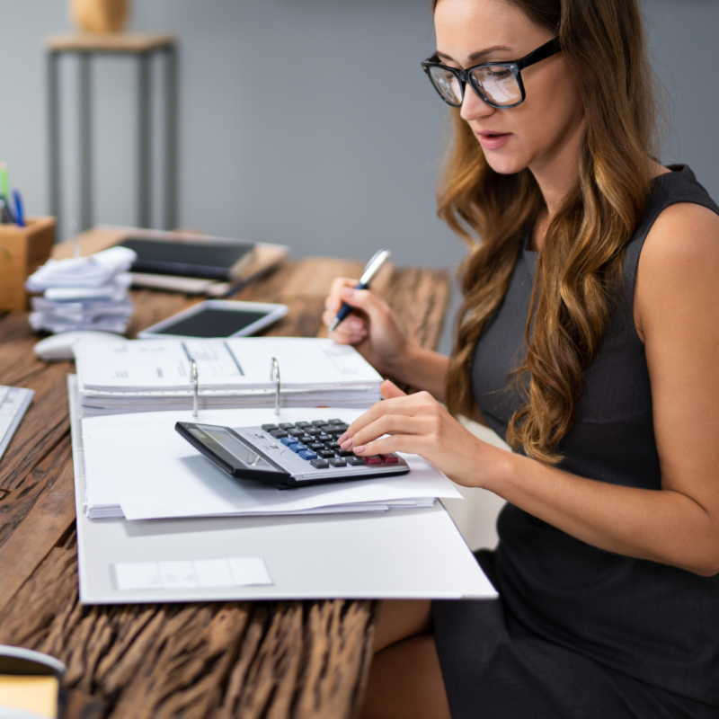 Pracownik biurowy przy komputerze - kobieta analizuje dokumenty i faktury w systemie KSeF